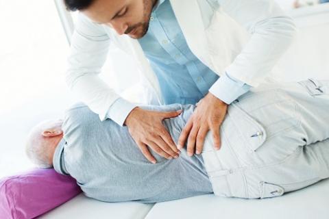 Infirmier pratiquant un massage à un homme allongé sur le côté